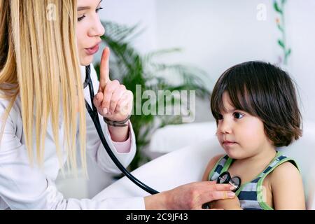 Kinderarzt untersucht Junge mit Stethoskop. Stockfoto