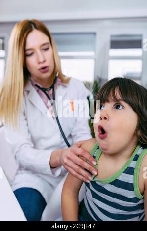 Kinderarzt untersucht Junge mit Stethoskop. Stockfoto