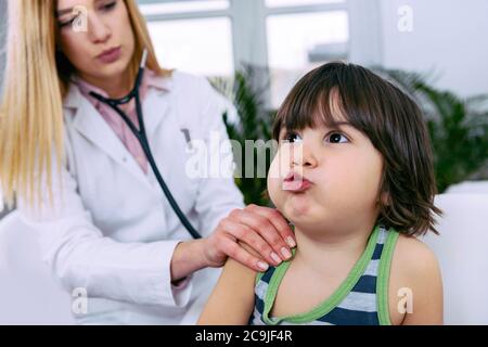 Kinderarzt untersucht Junge mit Stethoskop. Stockfoto