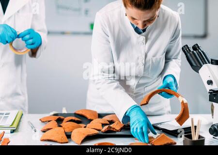 Archäologen rekonstruieren gebrochene Keramik im Labor. Stockfoto