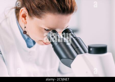 Porträt einer jungen Archäologin mit Mikroskop im Labor. Stockfoto