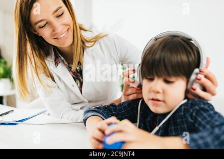 Junge, der einen Hörtest in der Praxis eines Audiologen macht. Stockfoto