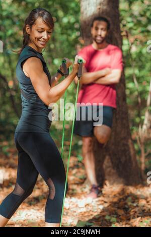 Junges Paar trainieren mit elastischen Widerstandsbändern in einem Park. Stockfoto