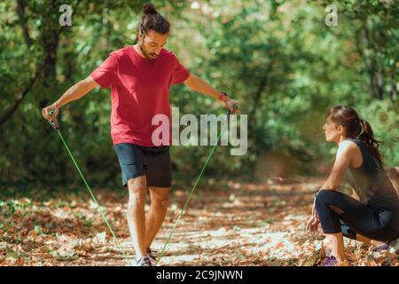 Junges Paar Training mit elastischen Widerstandsband im Freien im Park. Stockfoto