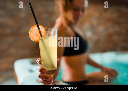 Frau genießt Whirlpool in einem Spa. Limonade trinken und entspannen. Stockfoto