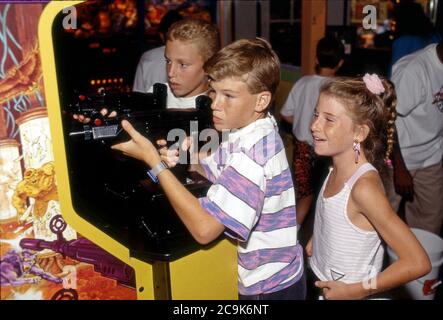 Amerikanische Kinder in Arcade spielen eine Waffe schießen Spiel. Stockfoto