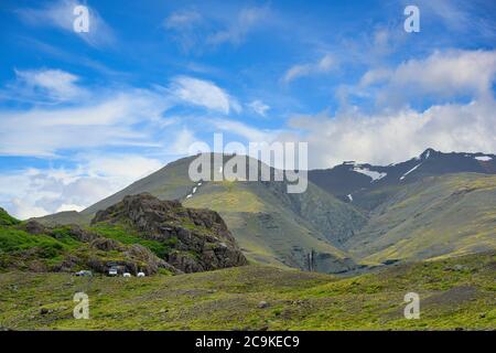 Viele Autos auf der Piste geparkt. Der Hintergrund sind hohe Berge mit grünem Gras überall in der Gegend. Im Sommer und blauen Himmel Tage auf dem Land in Stockfoto