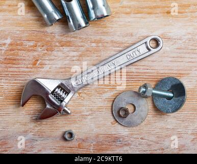 Verstellbarer Schraubenschlüssel auf Holzhintergrund. Hausreparaturkonzept Stockfoto