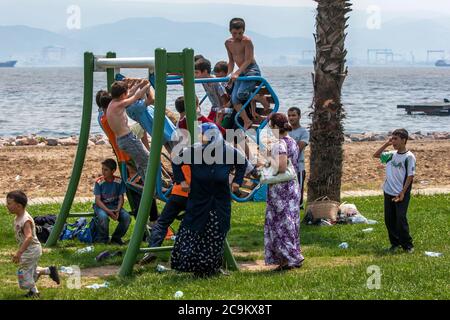 Türkische Kinder spielen kräftig auf einer Metallschaukel in einem Park neben dem Bosporus in Izmit in der Türkei. Stockfoto