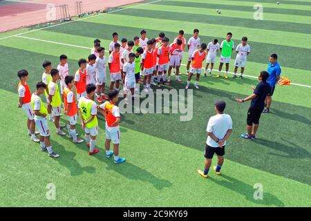 (200801) -- ZHENGZHOU, 1. August 2020 (Xinhua) -- Luftfoto vom 21. Juli 2020 zeigt die Trainercrew Gespräche mit Studenten der Henan Experimental High School Fußballmannschaft, die während einer Trainingseinheit an der Henan Experimental High School in Zhengzhou, der Hauptstadt der zentralchinesischen Provinz Henan, praktizieren. Als Sommerferien begannen, verbringen Fußballschüler der Henan Experimental High School rund 2 Stunden am täglichen Training in einer strengen Weise. Henan Experimental High School begann auf Campus Jugend Fußball Entwicklung im Jahr 2002 zu steigern. 2017 gewann das Team den Champion beim chinesischen Schoo Stockfoto