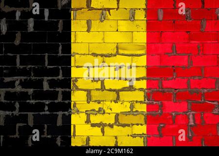 Die Nationalflagge Belgiens auf einer Wand aus Sibitblöcken mit Zement gemalt. Das Symbol des Landes. Stockfoto