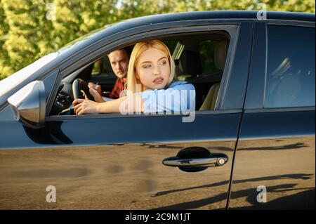 Frau und Instruktor schauen aus dem Autofenster Stockfoto