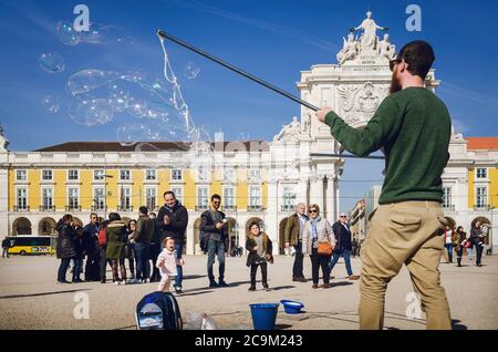 Lissabon, Portugal - 6. februar 2019: Straßenkünstler macht riesige Seifenblasen für Touristen und Kinder in Praca do Comercio, Hauptplatz von Lissabon, Por Stockfoto