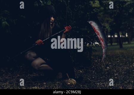 Porträt von Frau Teufel Geist Dämon Kostüm Horror halten gruselig oder Reaper auf der Hand, Happy Halloween Tag Konzept Stockfoto