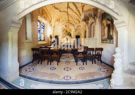 Sintra, Portugal - 5. Februar 2019: Kleine Kapelle mit Kreuz und Stuckarbeiten in Quinta da Regaleira Palace, Freimaurer-Anwesen der romantischen Zeit i. Stockfoto