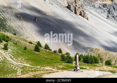 Denkmal auf dem Gipfel des Col d'Izoard (2360) mit der Casse Deserte im Hintergrund, Huates Alpes, Frankreich Stockfoto