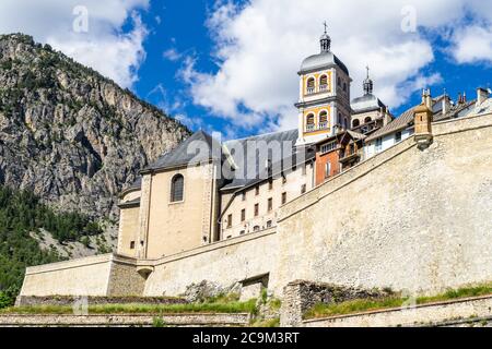 Die Stiftskirche Notre-Dame und Saint-Nicolas mit Blick auf die Stadtmauer von Briancon, Huates Alpes, Frankreich Stockfoto