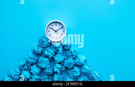Timing und Denkidee mit Papier zerknittert Kugel und weiße Uhr. Business-Performance Stockfoto