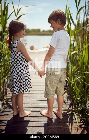 Bruder und Schwester in einem schönen Moment auf dem Dock des Sees Stockfoto