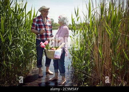 Glückliches altes Paar aufgeregt über Picknick an einem sonnigen Tag Stockfoto