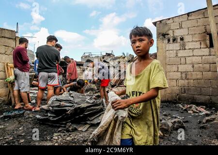 (200801) -- PEKING, 1. August 2020 (Xinhua) -- Bewohner suchen nach ihren Habseligkeiten aus ihren verkohlten Häusern nach einem Brand in einem Slum in Manila, Philippinen, 17. Juli 2020. (Xinhua/Rouelle Umali) Stockfoto