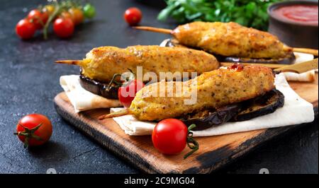 Lula Kebab mit gegrillter Aubergine auf Pita-Brot. Hähnchenkebabs auf einem Spieß mit Gemüse. Stockfoto