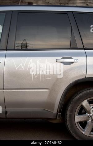 Das schmutzige Auto mit einer Aufschrift an der Hintertür Wash Me. Stockfoto