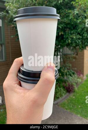 Zwei Kaffees zum Mitnehmen in einer Hand Stockfoto