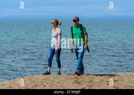 Burton Bradstock, Dorset, Großbritannien. August 2020. Wetter in Großbritannien. Ein Paar zu Fuß auf Freshwater Beach bei Burton Bradstock in Dorset an einem Tag der heißen sonnigen Zauber. Bild: Graham Hunt/Alamy Live News Stockfoto