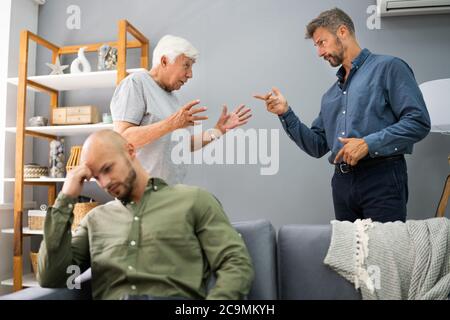 Großvater Mit Konflikt Mit Vater, Während Traurige Sohn Auf Der Couch Sitzen Stockfoto