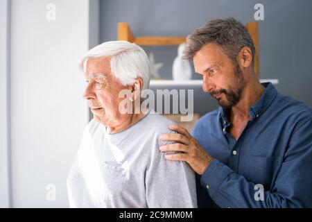 Alter Älterer Mann Mit Demenz, Der Unterstützung Und Pflege Vom Sohn Erhält Stockfoto