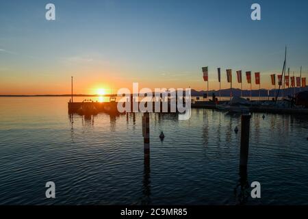 Panoramablick auf den Hafen am Ufer des Gardasees bei Sonnenuntergang, Bardolino, Verona, Venetien, Italien Stockfoto