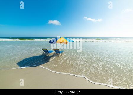 Strandliegen und Sonnenschirm in Daytona Beach. Florida, USA Stockfoto