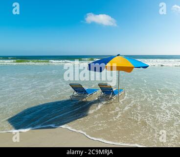 Liegestühle und Sonnenschirm in Daytona Beach. Florida, USA Stockfoto