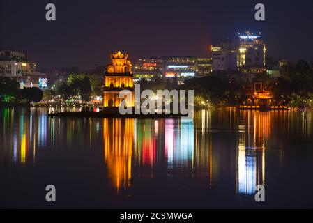 HANOI, VIETNAM - 13. DEZEMBER 2015: Turtle Tower vor der Kulisse der Stadt Waterfront des Hoan Kiem Lake Stockfoto