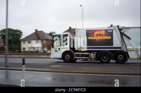 Ein Schlüsselarbeiter Southampton Stadt Müllsammelwagen zeigt einen Covid-19 Aufenthalt zu Hause schützen die NHS-Informationsbotschaft Poster auf der Seite. Stockfoto