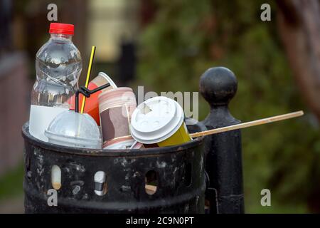 Schwarze Wahlurne überfüllt mit Müll aus Plastikflasche und Glasse, Papierglasse für Getränke. Stockfoto