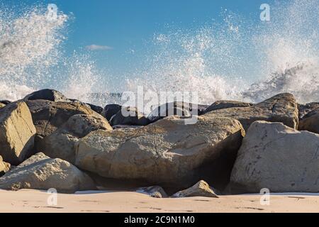 Wellen krachen über Felsen an einem Strand, auf der Insel Barbados Stockfoto