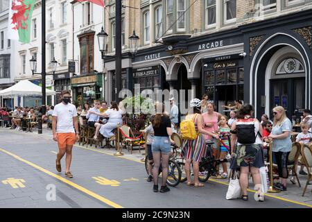 Während der Sperrzeit des Coronavirus versammeln sich Menschen in Cafés und Restaurants an der St. Mary's Street in Cardiff, Großbritannien. Stockfoto