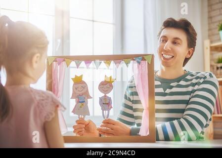 Glückliche liebevolle Familie. Vater und seine Tochter im Kinderzimmer. Lustige Papa und schönes Kind Spaß und spielen Leistung im Puppentheater drinnen Stockfoto