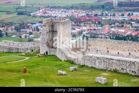 Turm und Mauern der Burgruine von Spis und der Stadt Spišské Podhradie im Hintergrund. Spisska Nova Ves, Slowakei. Stockfoto