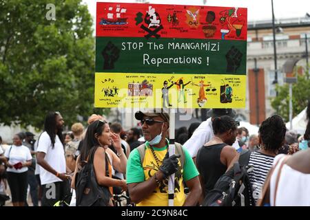 Demonstranten unterstützen Stop the Maangamizi Campaign und das African Emancipation Day Reparations March Committee während eines Protestes auf dem Windrush Square in Brixton, London. Eine Ausgangssperre und andere Beschränkungen wurden auf Demonstrationen in Süd-London geplant, um Menschen blockieren Hauptstraßen oder Planung illegaler Musikveranstaltungen, Scotland Yard hat gesagt, verhängt. Stockfoto