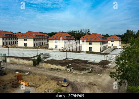 27. Juli 2020, Brandenburg, Elstal: Blick auf Neubauten auf dem Gelände des Olympischen Dorfes in Elstal in Brandenburg (mit Drohne erschossen). Seit Januar 2019 saniert der Nürnberger Immobilienentwickler terraplan das denkmalgeschützte Speisehaus der Nationen inklusive des ehemaligen Kesselhauses, dem zukünftigen Haus Central. Darüber hinaus werden weitere neue Wohngebäude rund um diese Gebäude errichtet. Insgesamt werden in der ersten Bauphase bis 2022 rund 365 Wohnungen gebaut. Foto: Paul Zinken/dpa-Zentralbild/ZB Stockfoto