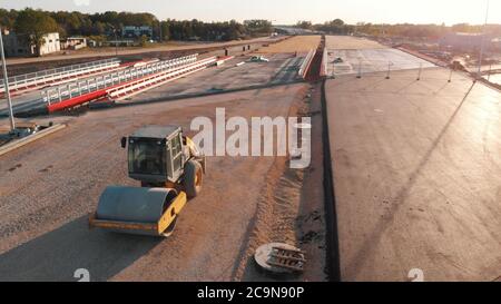 Asphaltfertiger Maschine und Dampf Straßenwalze während des neuen Straßenbaus Luftbild Stockfoto