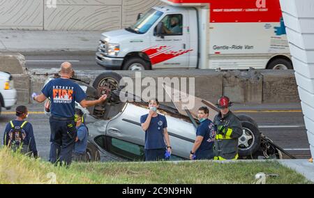 Detroit, Michigan - Detroit Feuerwehrleute inspizieren ein kopfüber unten zerstörtes Auto auf Interstate-94. Stockfoto