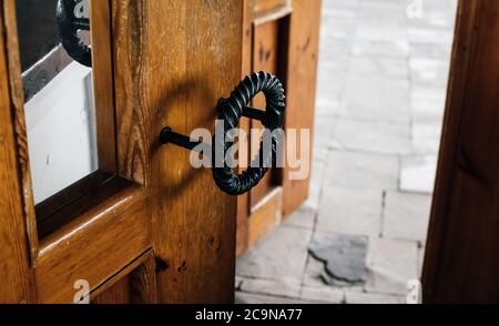 Vintage Holztür mit antikem geschmiedeten Metallic Rundgriff Nahaufnahme Stockfoto