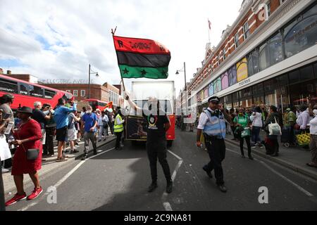 Demonstranten, die die Kampagne Stop the Maangamizi und das Komitee vom Afrikanischen Emancipation Day Reparations March unterstützen, nehmen an einem marsch vom Windrush Square zum Max Roach Park in Brixton, London, Teil. Eine Ausgangssperre und andere Beschränkungen wurden auf Demonstrationen in Süd-London geplant, um Menschen blockieren Hauptstraßen oder Planung illegaler Musikveranstaltungen, Scotland Yard hat gesagt, verhängt. Stockfoto