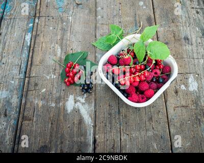 Reife und saftige Beeren auf altem Holzhintergrund. Selektiver Fokus Stockfoto