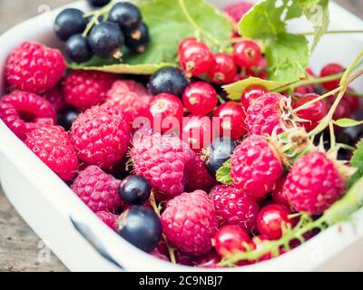 Reife und saftige Beeren auf altem Holzhintergrund. Selektiver Fokus Stockfoto