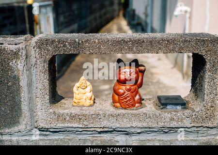 Japanische glückliche Katze maneki neko in japanischen alten Dorf Uchiko Stadt in Ehime, Shikoku, Japan Stockfoto